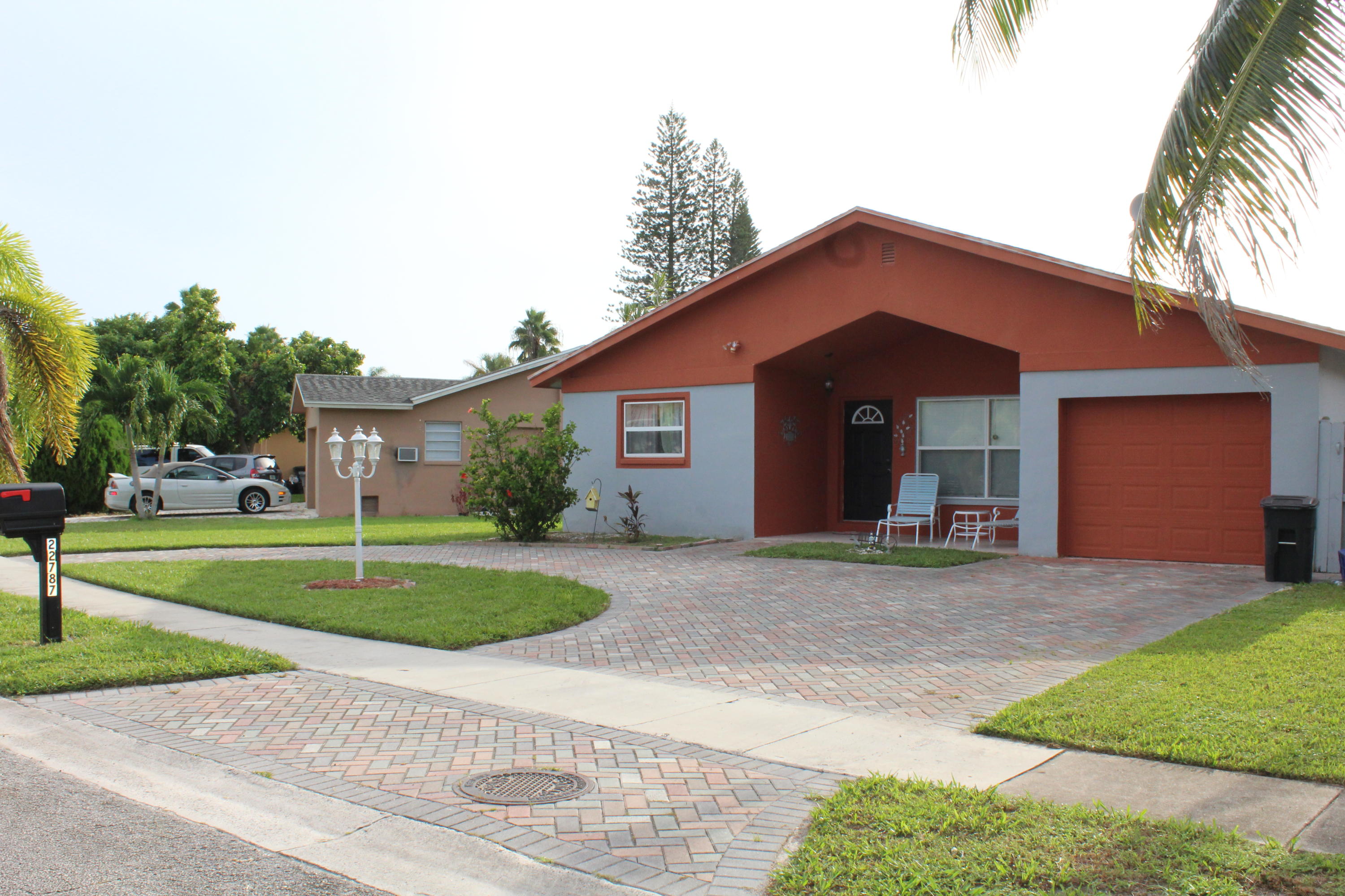 22787 Southwest 65th Way Boca Raton, FL 33428 - Photo 1 of 18 a front view of a house with a yard and potted plants