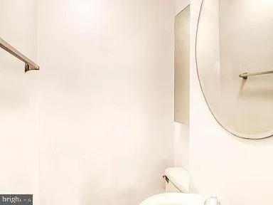 a bathroom with a toilet and a mirror