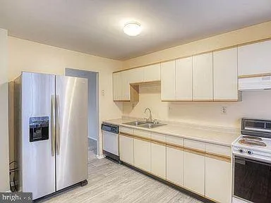 a kitchen with stainless steel appliances granite countertop a refrigerator sink and cabinets