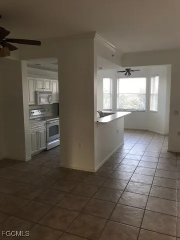 a kitchen with stainless steel appliances a stove a sink and white cabinets