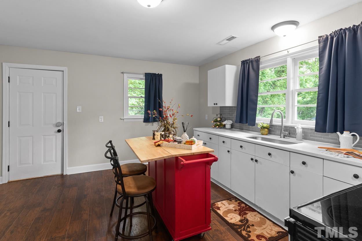 5314 Fayetteville Road Durham, NC 27713 - Photo 5 of 24 a kitchen with a dining table chairs sink and wooden floor