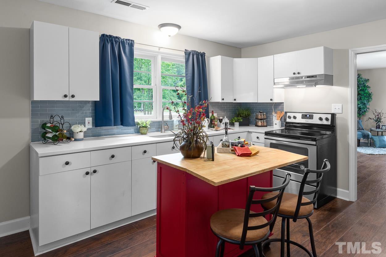 5314 Fayetteville Road Durham, NC 27713 - Photo 6 of 24 a kitchen with stainless steel appliances kitchen island granite countertop a dining table chairs sink refrigerator and cabinets