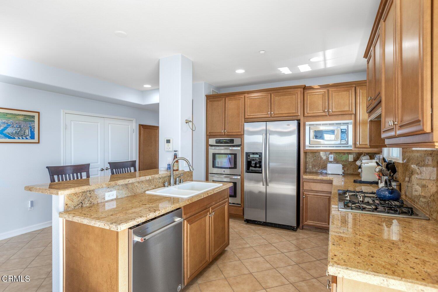 1481 Windshore Way Oxnard, CA 93035 - Photo 12 of 31 a kitchen with stainless steel appliances granite countertop a sink a stove and a refrigerator