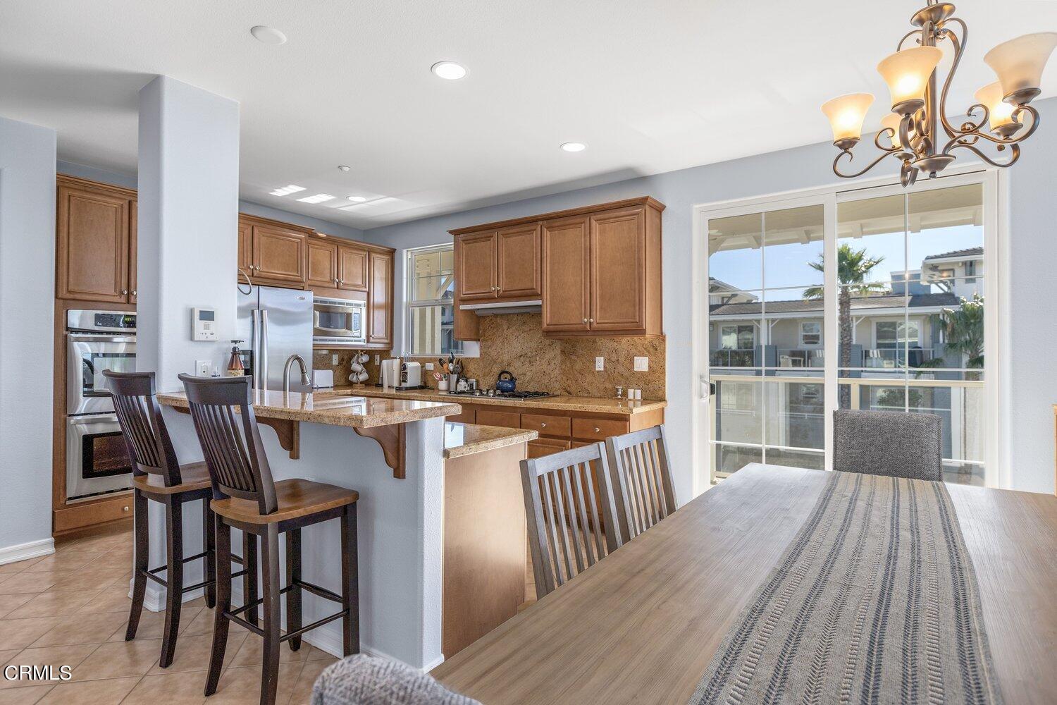 1481 Windshore Way Oxnard, CA 93035 - Photo 13 of 31 a kitchen with a dining table chairs and wooden floor