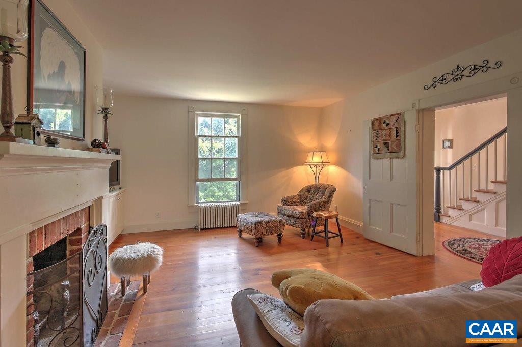 528 Top Ridge Road Stanardsville, VA 22973 - Photo 12 of 45 a living room with furniture a fireplace and a large window