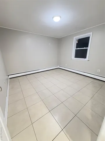 a view of an empty room with wooden floor and stairs