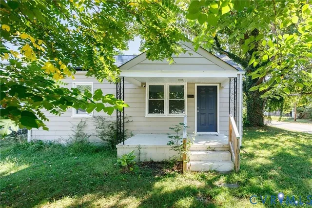 a front view of a house with a yard and potted plants