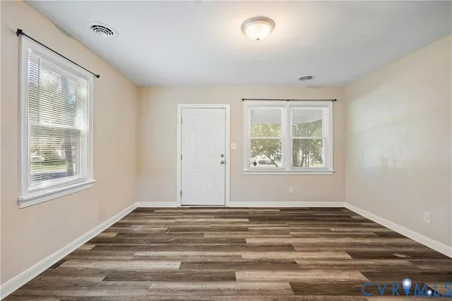 a view of a room with wooden floor and window