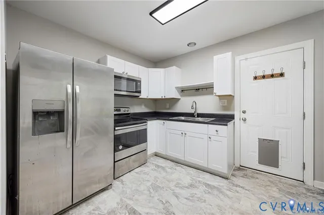 a kitchen with stainless steel appliances granite countertop a refrigerator and a stove