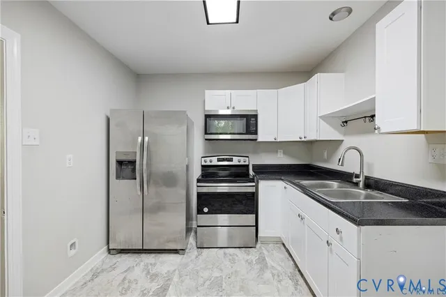 a kitchen with granite countertop a refrigerator and a sink