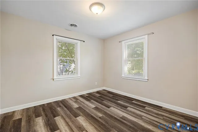 a view of a room with wooden floor and windows