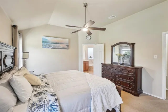 a bedroom with a bed a chandelier and a dresser