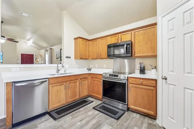 a kitchen with stainless steel appliances granite countertop a stove sink and cabinets