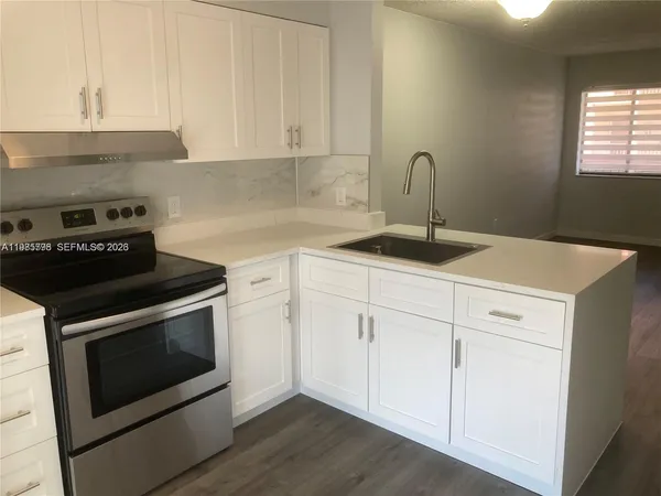 a kitchen with a stove and white cabinets