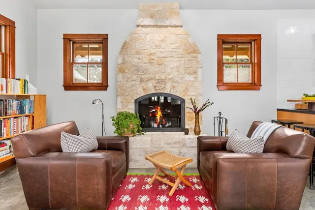 a living room with furniture a fireplace and a window