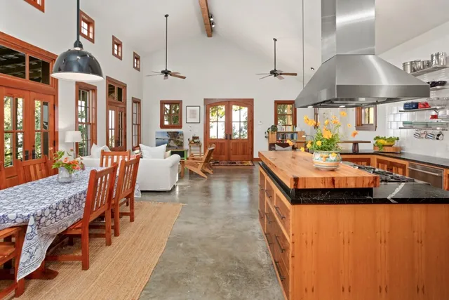a kitchen with stainless steel appliances granite countertop a sink a stove and a wooden floors