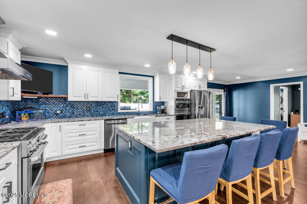 225 East Bird Village Road Jackson, NJ 08527 - Photo 18 of 69 a kitchen with a dining table chairs cabinets and stainless steel appliances