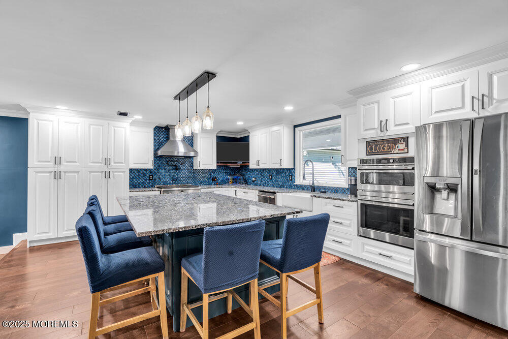 225 East Bird Village Road Jackson, NJ 08527 - Photo 20 of 69 a kitchen with granite countertop a table chairs microwave and refrigerator