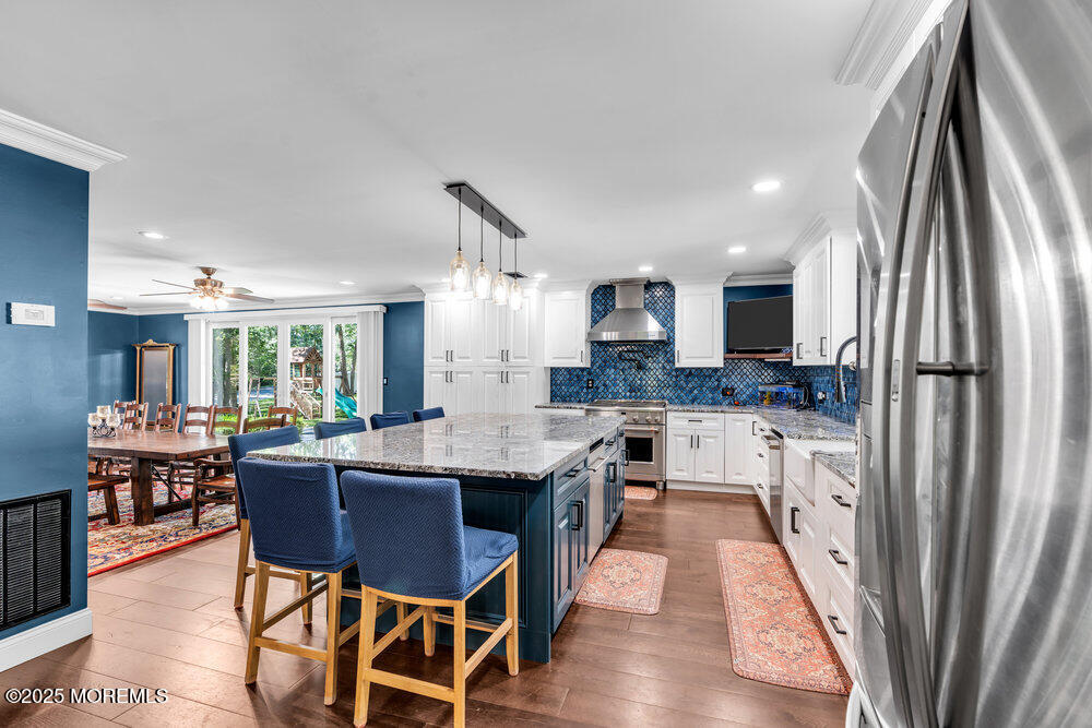 225 East Bird Village Road Jackson, NJ 08527 - Photo 22 of 69 a kitchen with stainless steel appliances a dining table chairs and a wooden floor