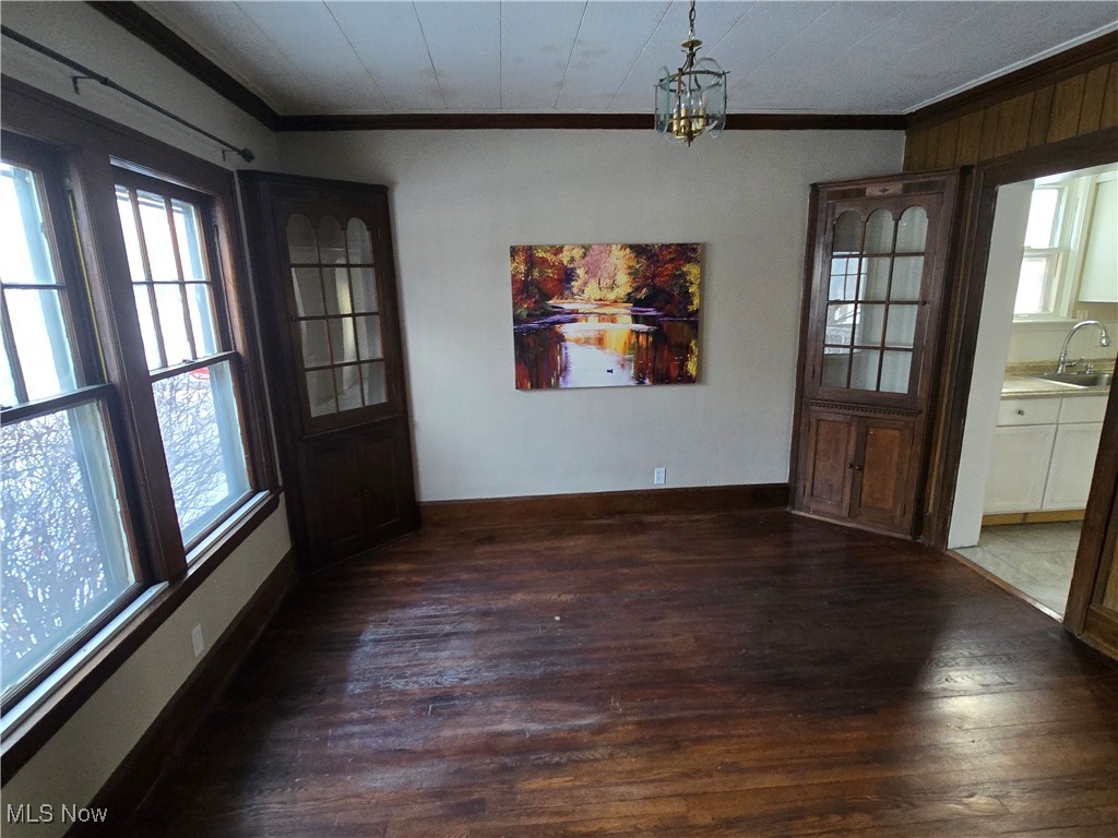 2048 Rossmoor Road Cleveland Heights, OH 44118 - Photo 15 of 29 Unfurnished dining area with ornamental molding, wood-type flooring, and a chandelier
