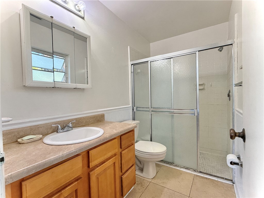 715 Holly Road Vero Beach, FL 32963 - Photo 18 of 25 a bathroom with a granite countertop sink toilet a mirror and shower
