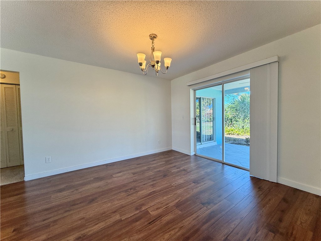715 Holly Road Vero Beach, FL 32963 - Photo 6 of 25 a view of an empty room with wooden floor and a window