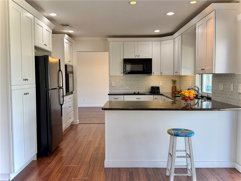 715 Holly Road Vero Beach, FL 32963 - Photo 8 of 25 a kitchen with stainless steel appliances a refrigerator and a stove top oven