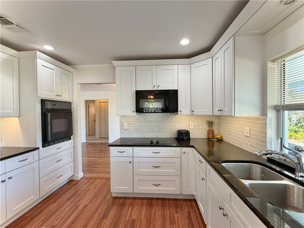 715 Holly Road Vero Beach, FL 32963 - Photo 10 of 25 a kitchen with white cabinets sink and stainless steel appliances