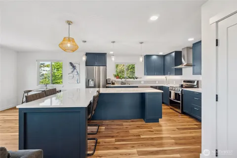 a kitchen with stainless steel appliances kitchen island granite countertop a sink a stove counter space and cabinets