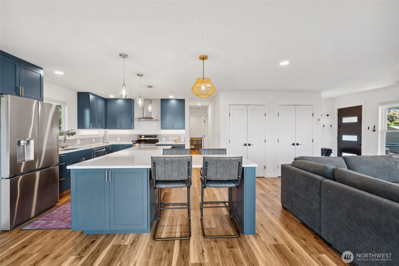 201 South State Street, Unit B Bellingham, WA 98225 - Photo 13 of 40 a kitchen with stainless steel appliances granite countertop a refrigerator a sink dishwasher a stove and a dining table with wooden floor