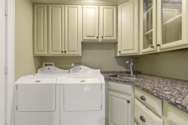 a utility room with a sink washer and dryer