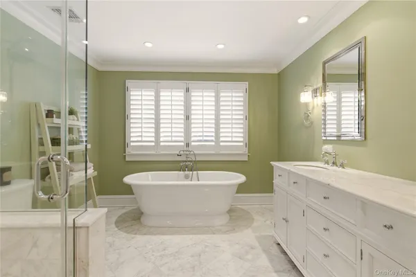 a spacious bathroom with a bathtub sink and mirror