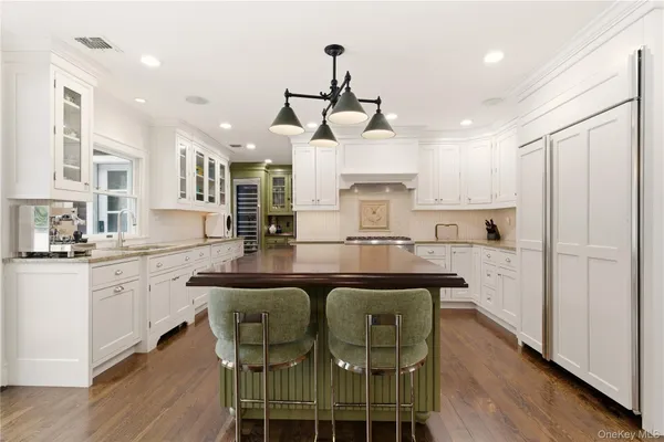 a kitchen with stainless steel appliances kitchen island granite countertop a sink and a refrigerator