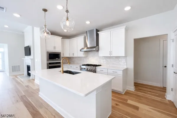 a large kitchen with stainless steel appliances kitchen island a large counter space a sink dishwasher a refrigerator and cabinets
