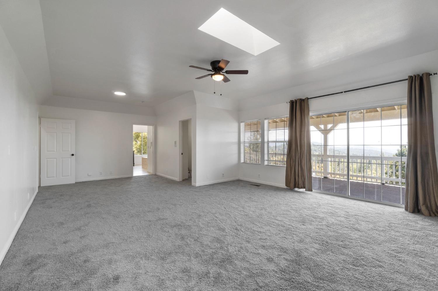 2832 East Westfall Road Mariposa, CA 95338 - Photo 18 of 38 an empty room with chandelier fan and windows