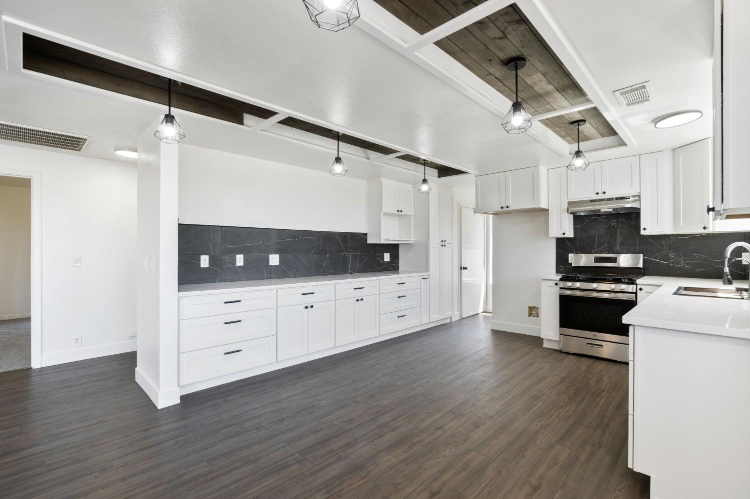 2832 East Westfall Road Mariposa, CA 95338 - Photo 8 of 38 a kitchen with stainless steel appliances white cabinets and wooden floor