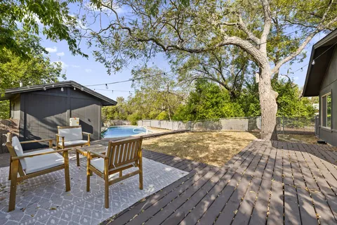 a view of a backyard with table and chairs under an umbrella