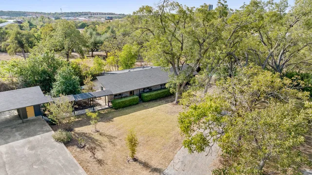 an aerial view of a house with yard and mountain view in back