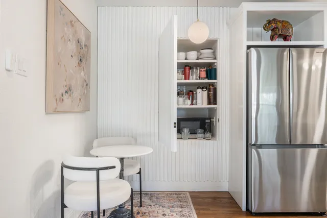 a kitchen with stainless steel appliances granite countertop a refrigerator and a wooden floor