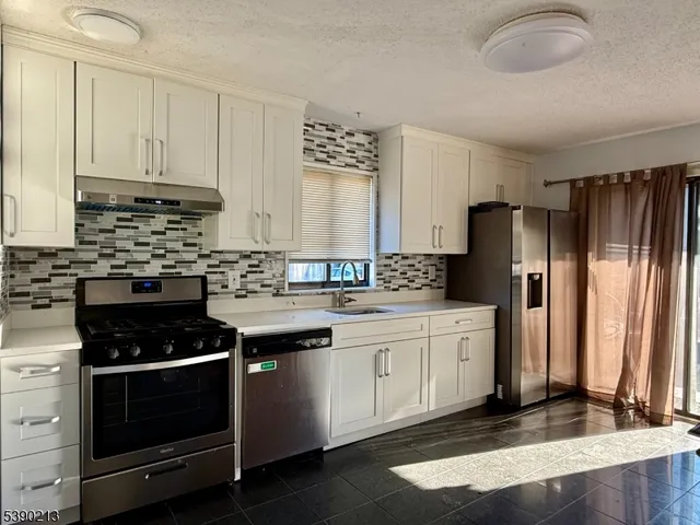 a kitchen with kitchen island a sink stove and cabinets