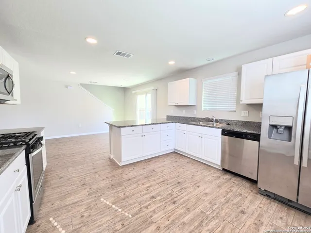 a view of a kitchen with white cabinets