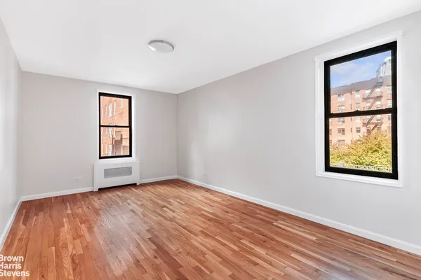 a bedroom with a bed wooden floor and window