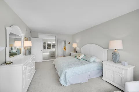 a large bedroom with a bed and large window
