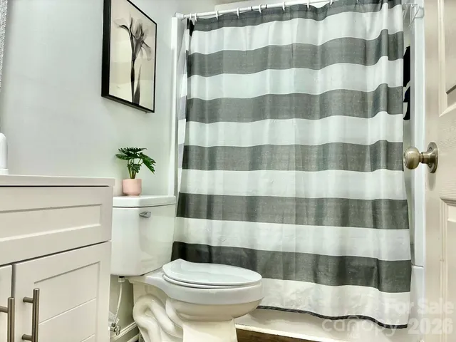 a white toilet sitting next to a shower curtain