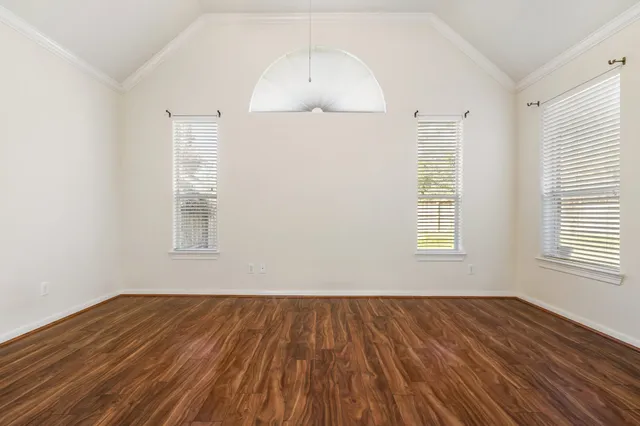 wooden floor in an empty room with a window