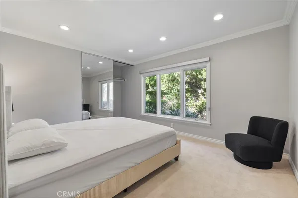 a bedroom with a bed and a couch with window