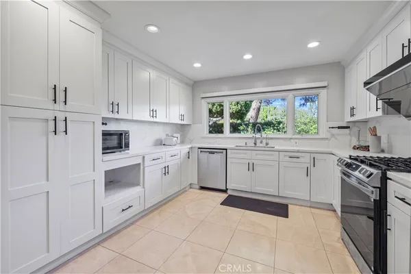 a kitchen with white cabinets and white appliances