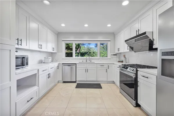 a kitchen with a white stove top oven and cabinets