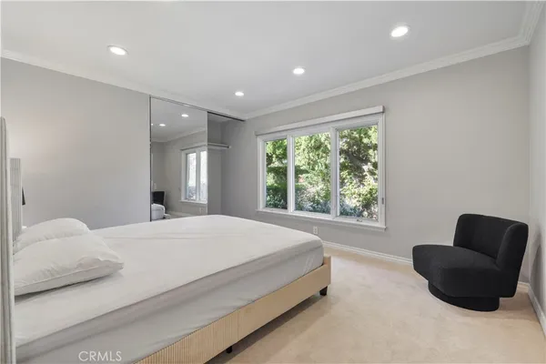 a bedroom with a bed and a couch with window