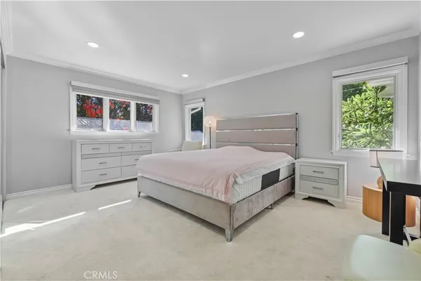 a spacious bedroom with a bed and a painting on the wall